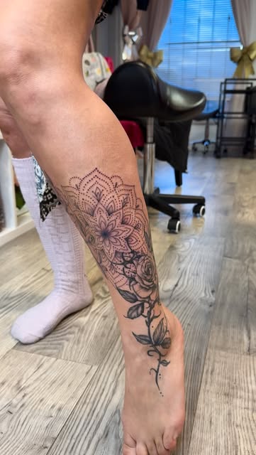 Dotwork mandala flowing into fine line florals from calf to ankle
