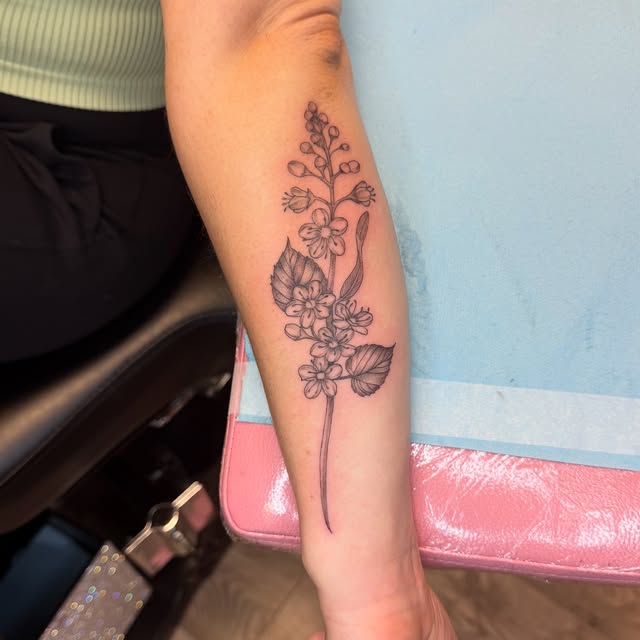 Fine line sprig of blossoms on the forearm, a wedding keepsake