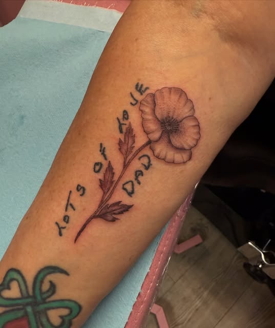 Poppy with handwritten "lots of love dad" script on the forearm