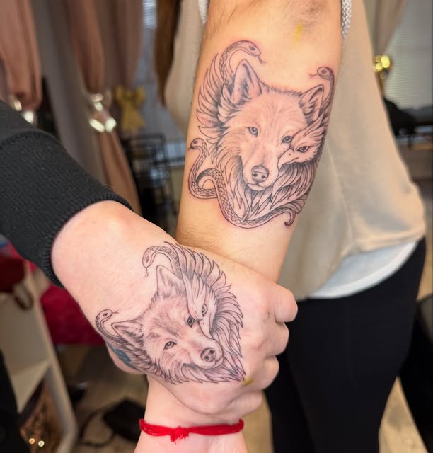 Matching black and grey wolf, phoenix and serpent tattoos on forearm and hand