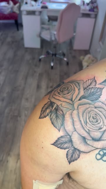 Black and grey roses on the shoulder, freshly done with bandage edge