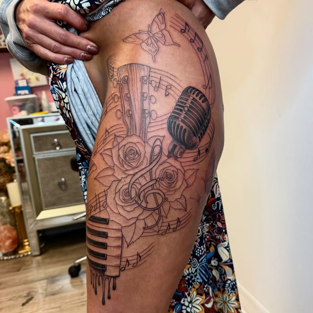 Music-themed hip piece with guitar, microphone, piano keys and roses