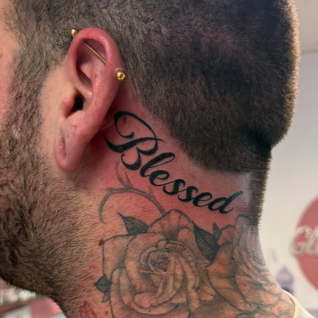 Script "Blessed" on the side of the neck above a rose