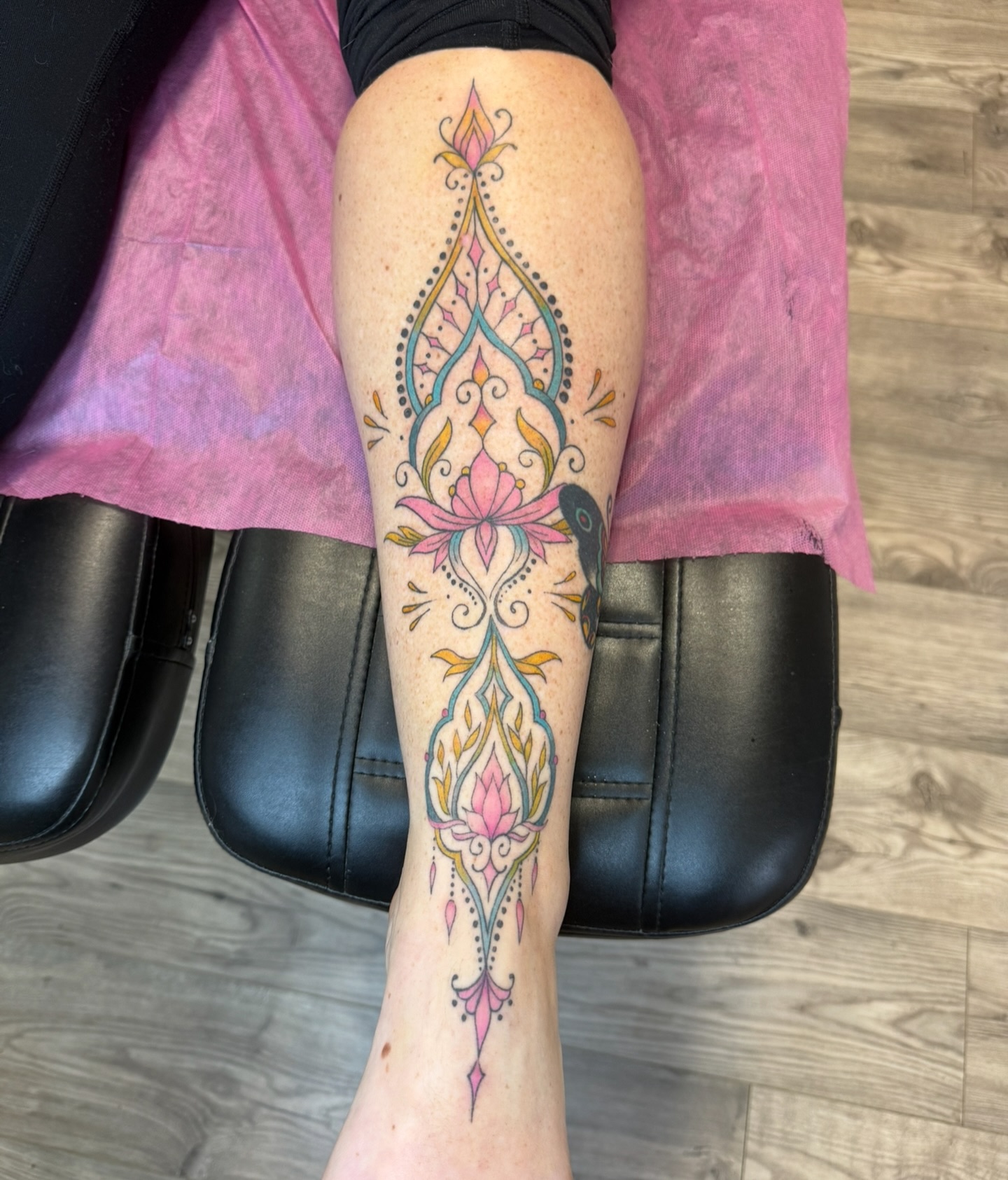 Ornate colour lotus and filigree design running down the shin and calf