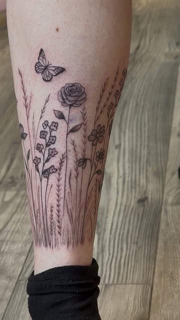 Wildflower field with butterfly and rose wrapped around the lower leg