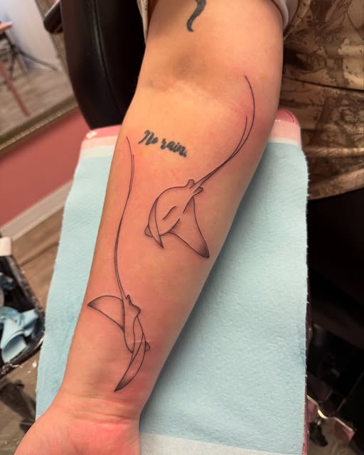 Fine line stingray with small script on the forearm