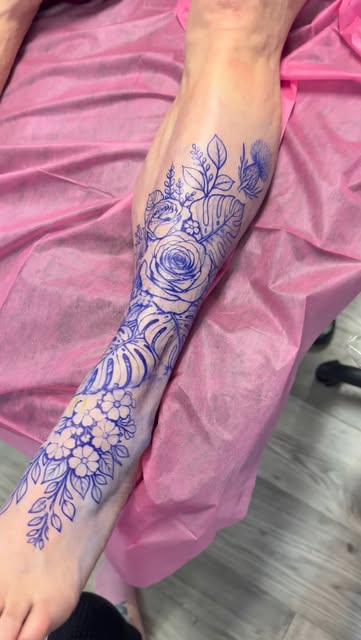 Blue stencil of roses and leaves on the lower leg before tattooing