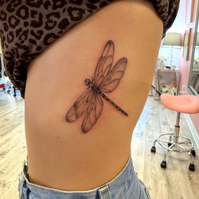Fine line dragonfly on the rib cage