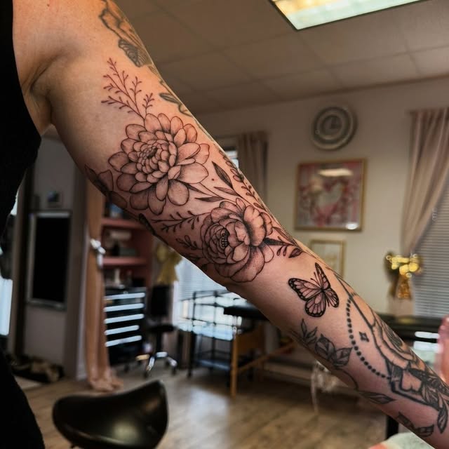 Peonies, botanicals and a butterfly flowing wrist to elbow on the arm