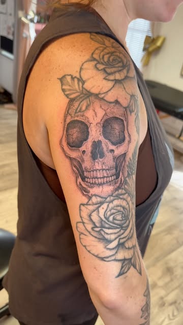 Black and grey skull with roses on the upper arm