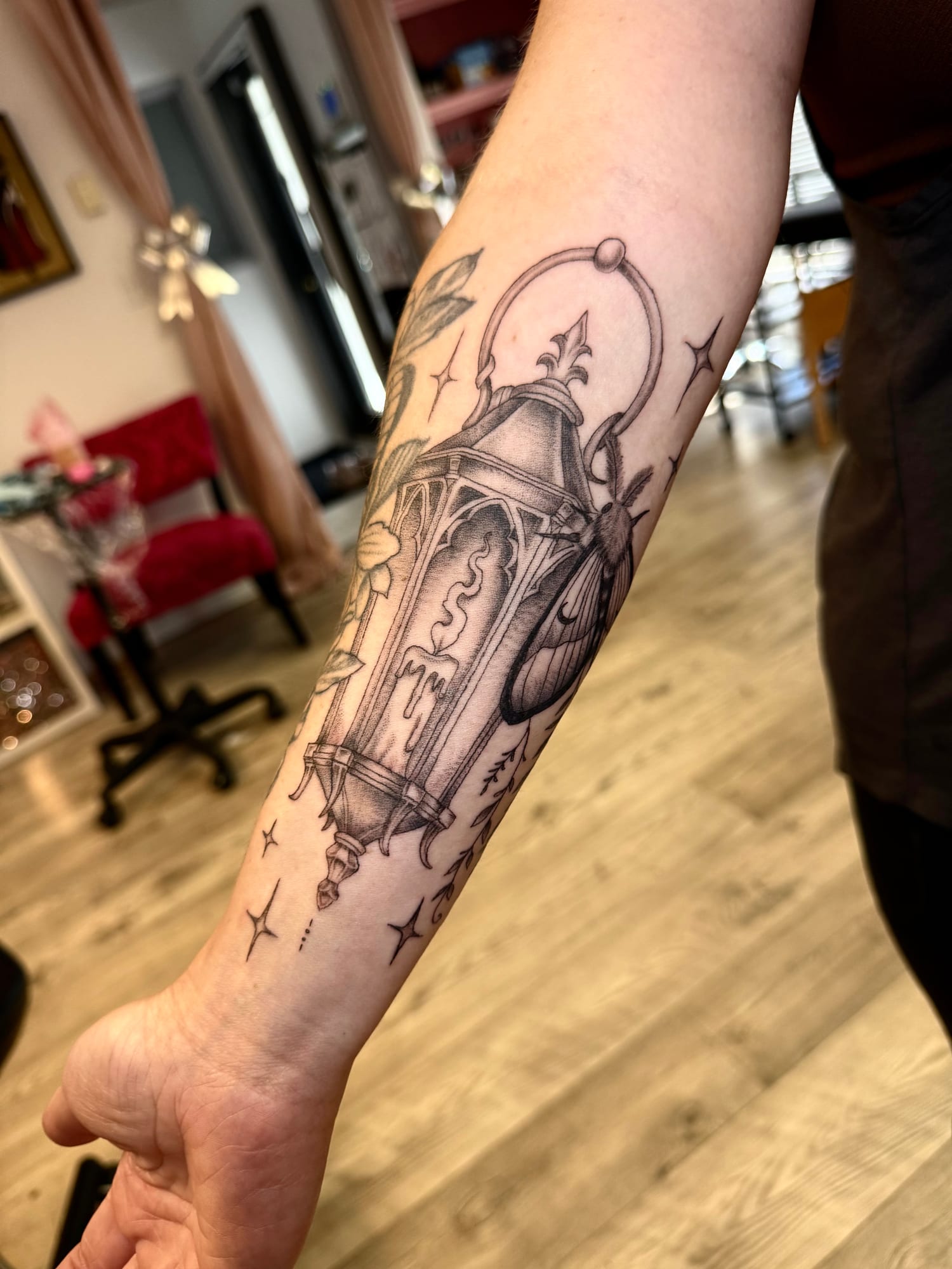 Black and grey ornate lantern with sparkles on the forearm