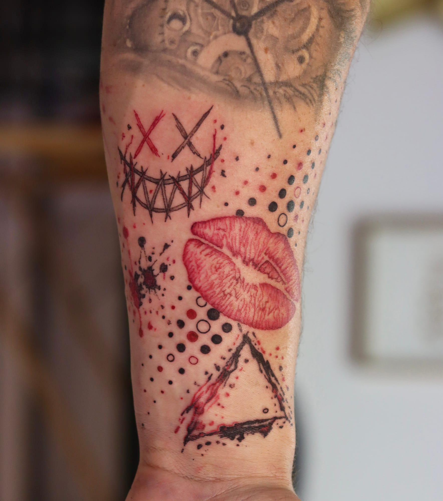 Red lips, halftone dots and a geometric triangle on the forearm