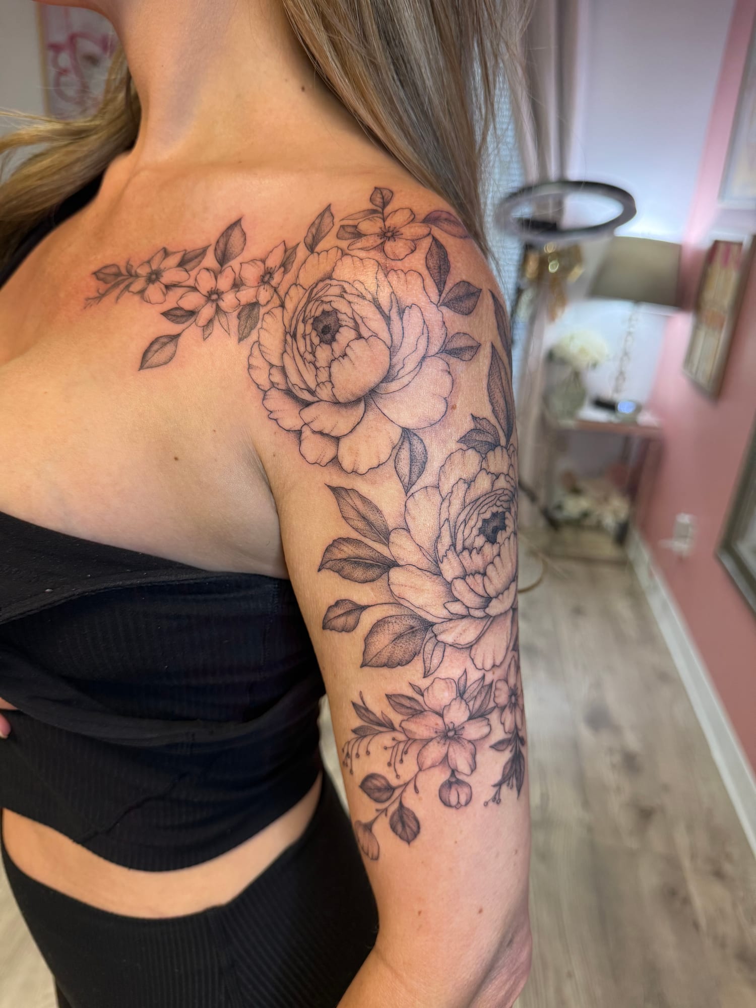 Fine line roses and blossoms over the shoulder and upper arm