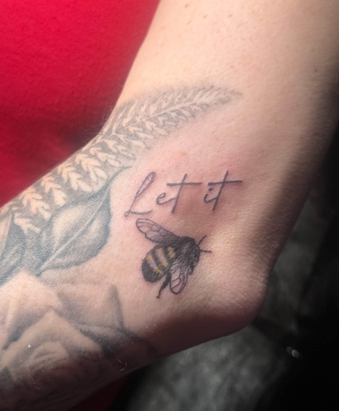 Small bumblebee with “Let it be” script, tucked beside a larger floral piece