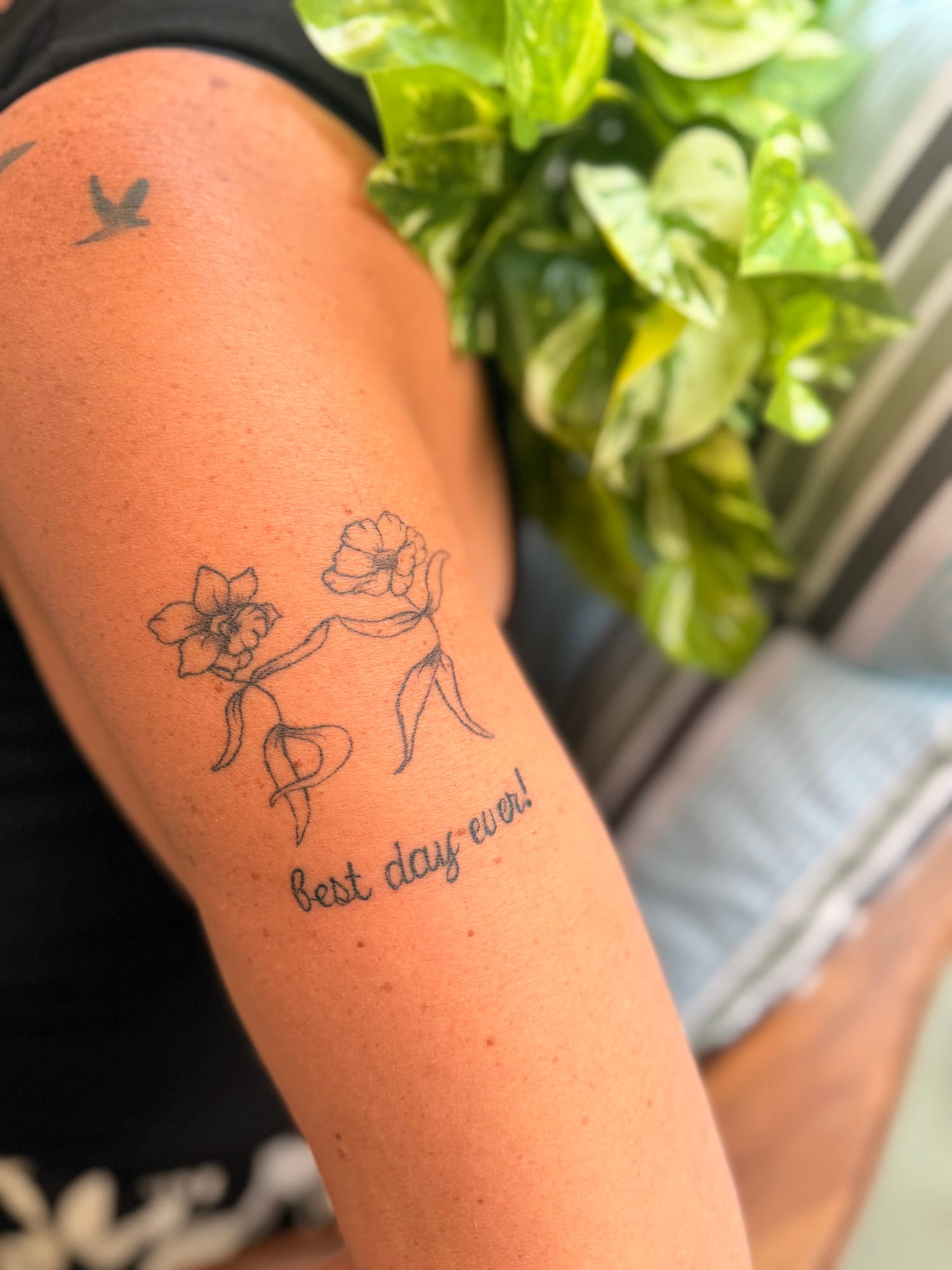Fine line poppies above the script “best day ever!” on the upper arm